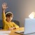 school-boy-yellow-shirt-taking-virtual-classes-raising-hand